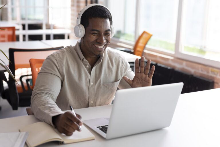Benefícios estudar inglês em 2024: saiba mais! | Foto de um homem sorrindo enquanto estuda online | IP School