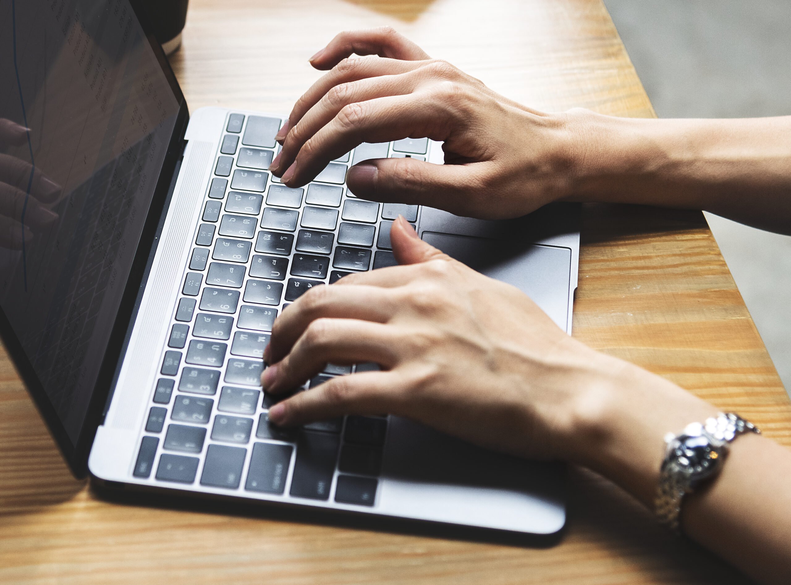 Como escrever um email profissional em inglês? | Foto das mãos de uma mulher digitando no notebook | IP School